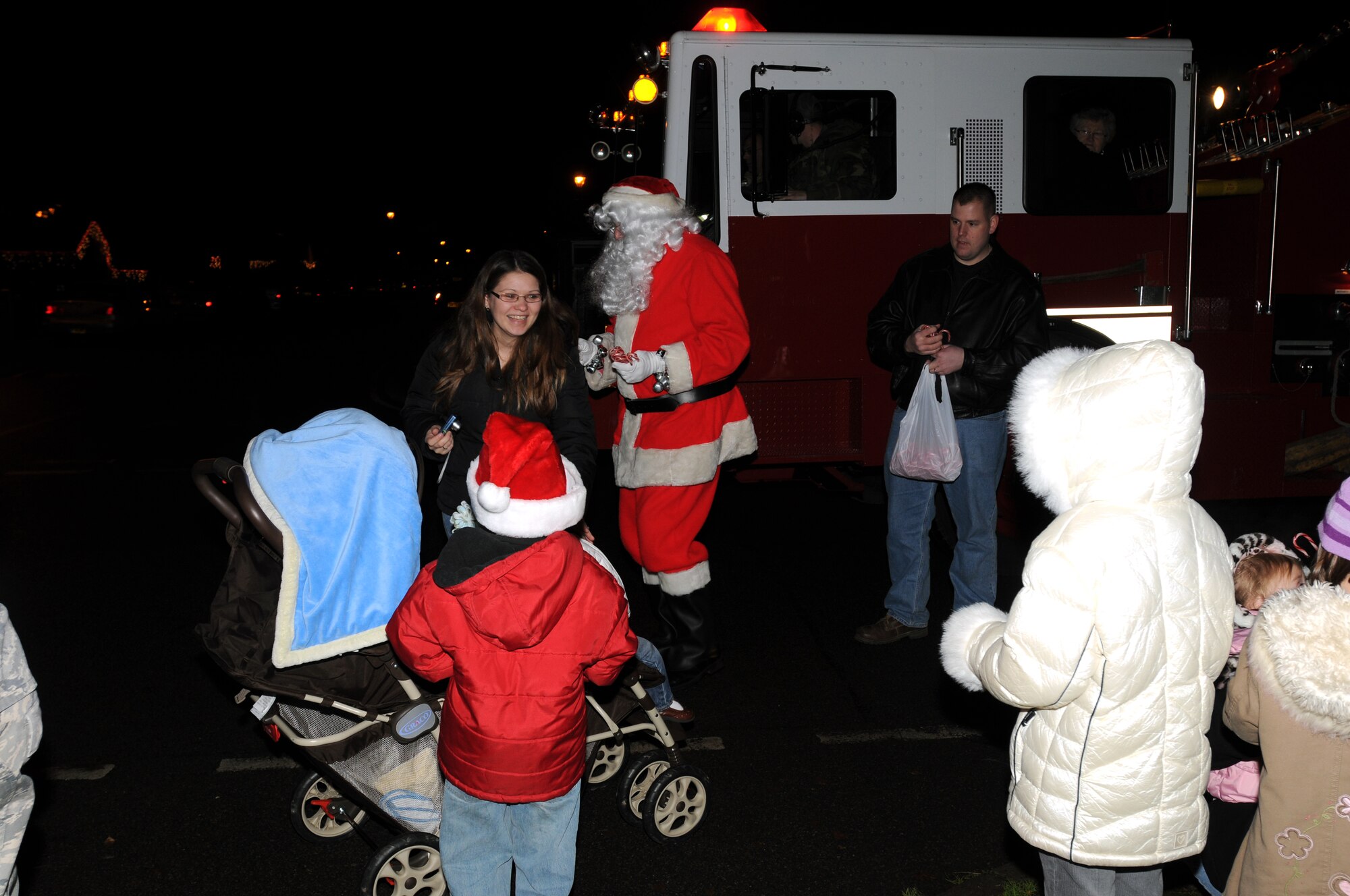 Children and parents gather together as Santa Claus steps off of a fire truck Dec. 16 on RAF Feltwell, England. Santa visits RAF Feltwell every year to deliver candy canes and talk to the young children. (U.S. Air Force photo by Senior Airman Kristopher Levasseur)