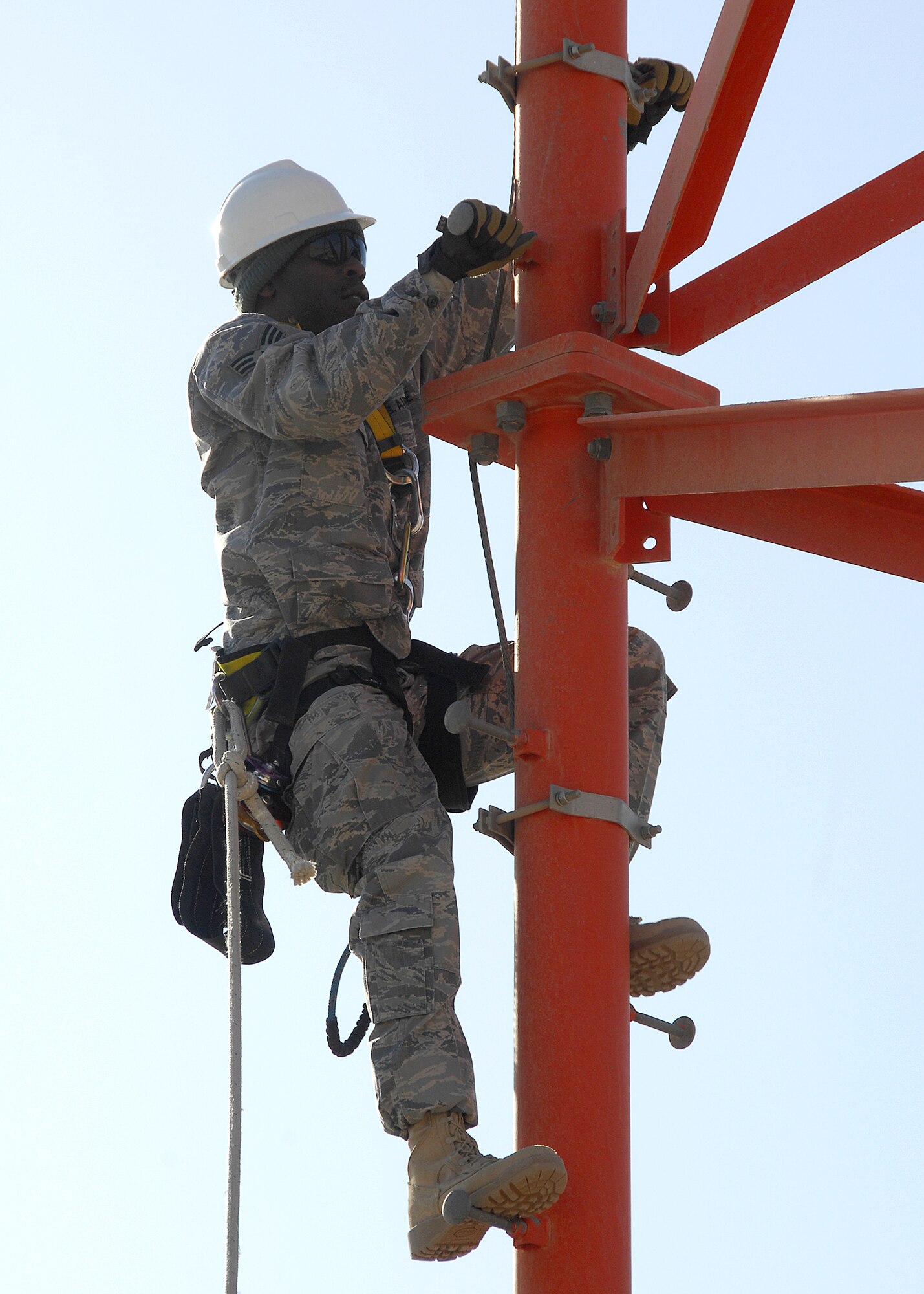 SOUTHWEST ASIA -- Senior Airman Lakendrick Fisher, 386th Expeditionary Communication Squadron Cable and Antenna Maintenance technician, climbs a communications tower to install a Radio Over Internet Protocol (ROIP) antenna on Dec. 15 at an air base in Southwest Asia. The 386th ECS Cable Maintenance shop provides command and control capabilities through installation, maintenance, fault isolation and reconstitution of fixed cable and wireless distribution systems, local area networks and wide area networks in support of tactical and strategic operations. Airman Fisher is deployed from Yokota Air Base, Japan.  (U.S. Air Force photo/Tech. Sgt. Raheem Moore)
