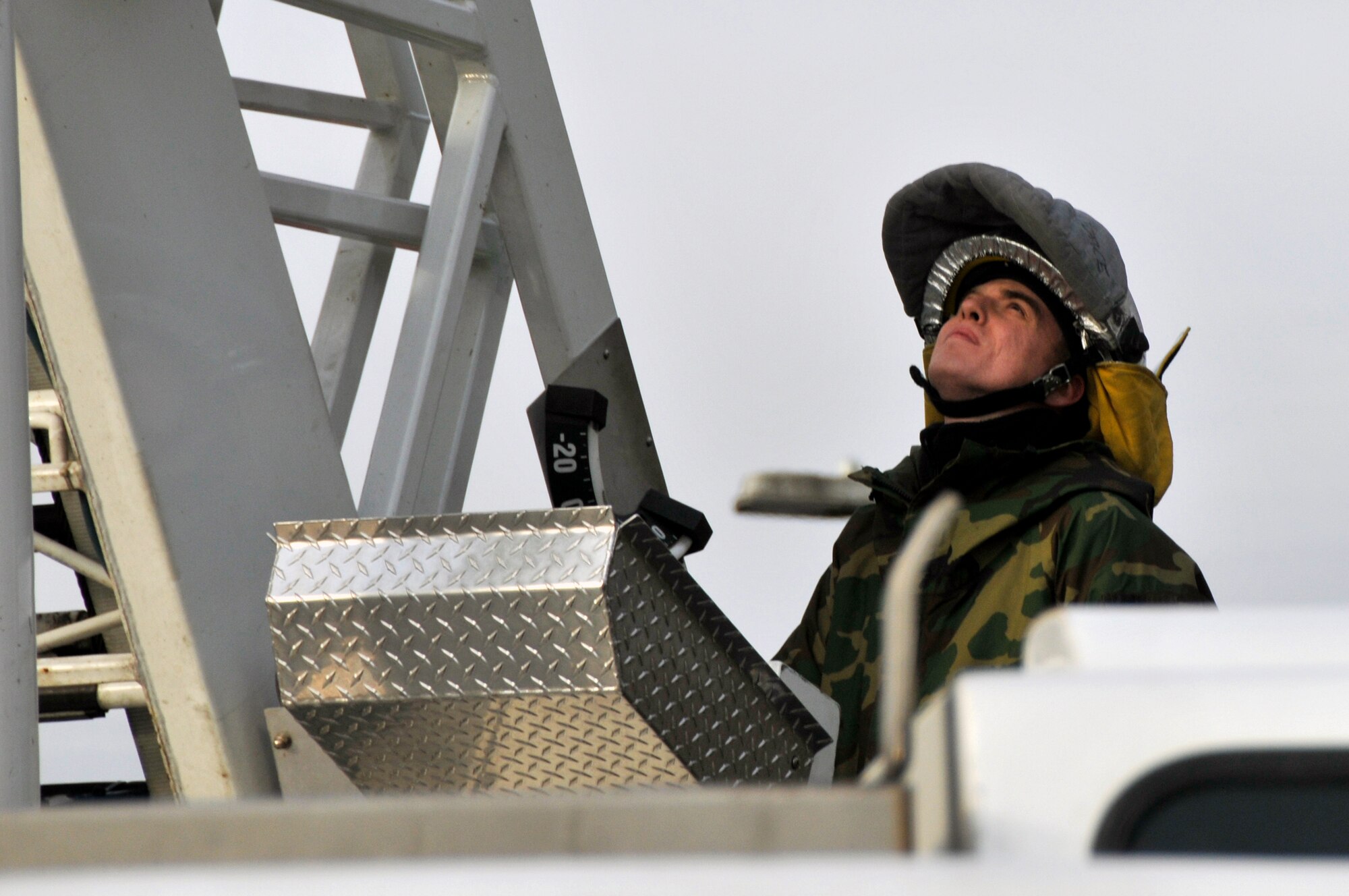 Senior Airman Christopher Gaines, 48th Civil Engineer Squadron fire fighter extends the ladder over the archeological excavation site Dec. 12 at RAF Lakenheath, England. Liberty fire fighters provided their platform ladder truck so aerial photos of the site can be taken. (U.S. Air Force photo by Airman 1st Class Perry Aston) 
