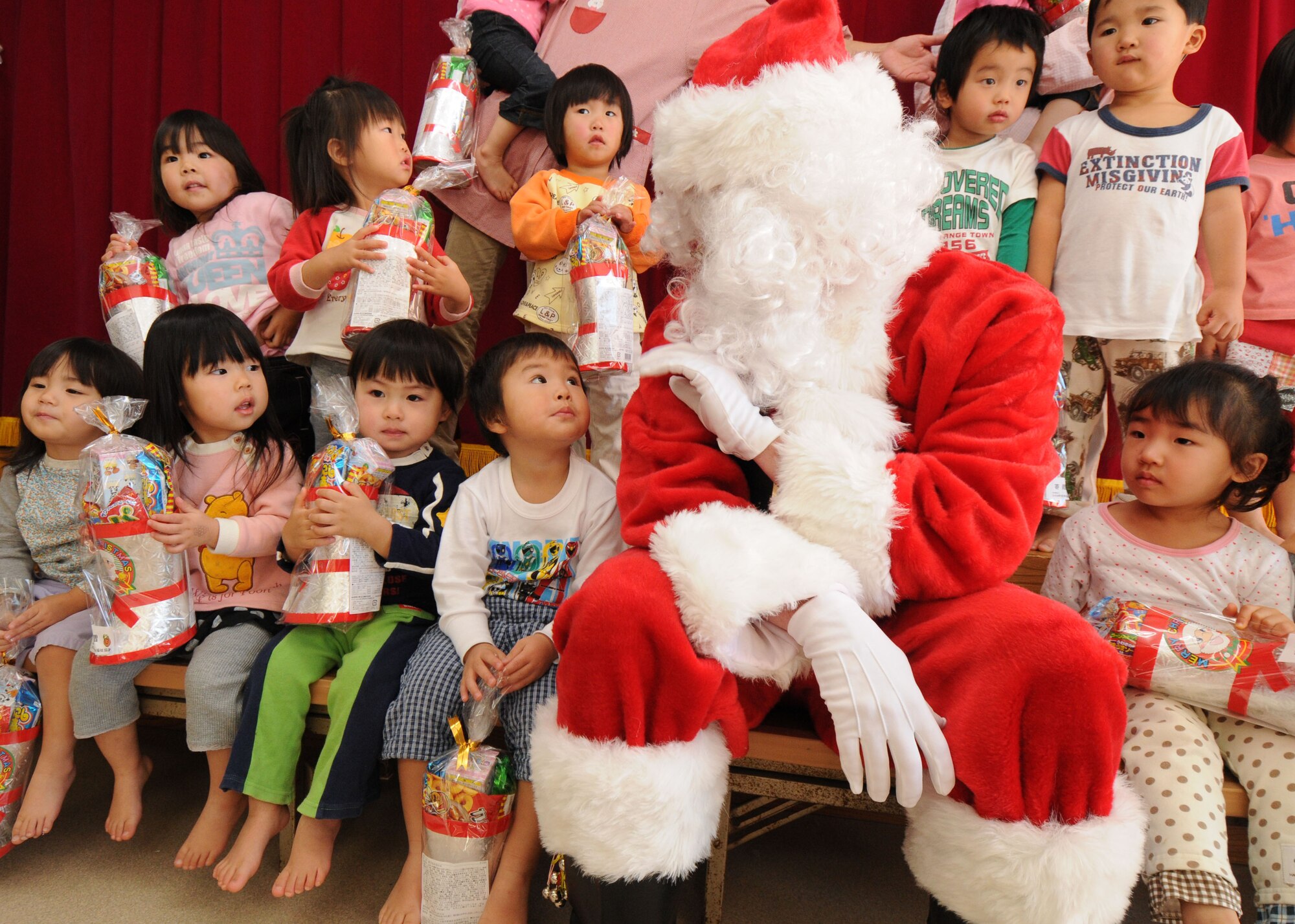 YOKOTA AIR BASE, Japan --  Airman Sean "Santa" Martin from the 374th Airlift Wing Public Affairs office takes a photo with children at the Taisho elementary school, Hinoda City, Dec. 18. While there, Airman Martin also handed out gifts and answered any question they had for Santa.
(U.S. Air Force photo by Senior Airman Veronica Pierce)