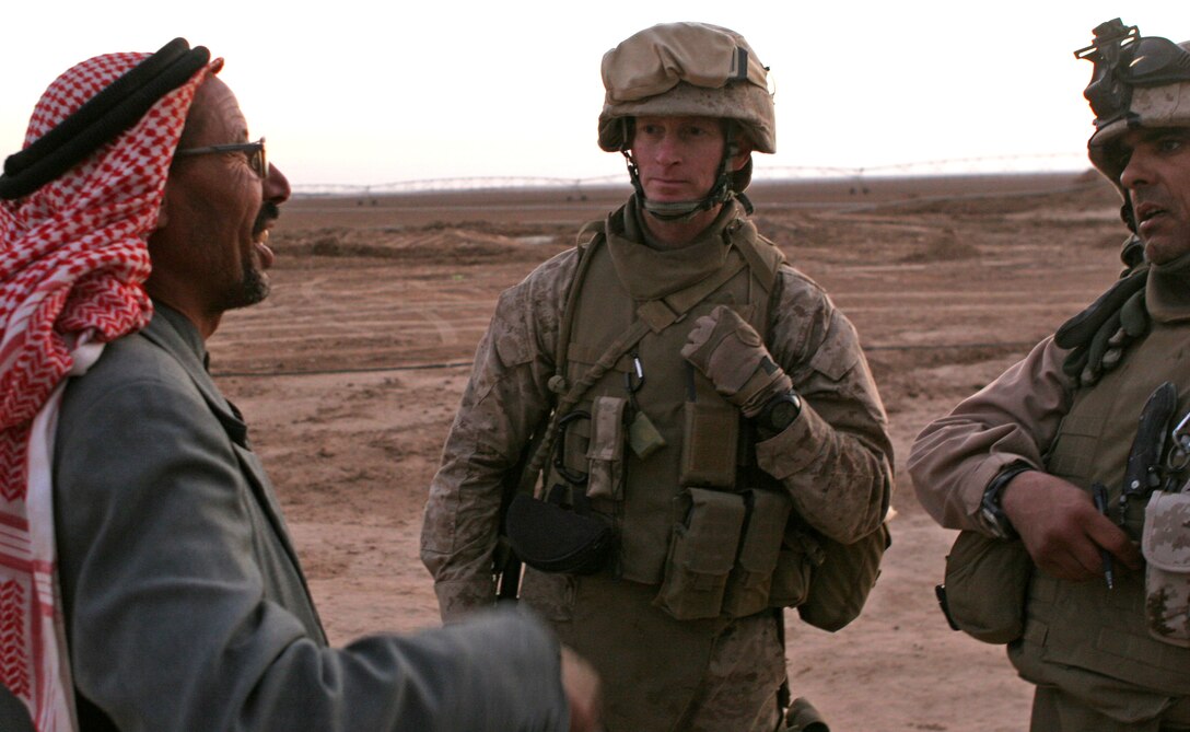 Marine Corps Lt. Col. Andrew J. Drake, plans officer, Jump Command Point, Multinational Force West, and a linguist speak with Ali Awad, an Iraqi farmer, outside Baaj, Iraq, to build relations with the Marines’ Iraqi neighbors. U.S. Marine Corps photo by Cpl. Sean P. McGinty