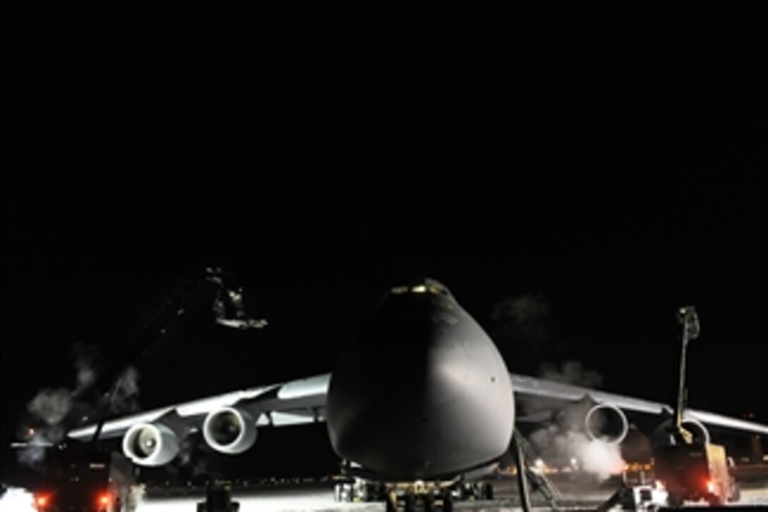 Two de-icing vehicles work on a C-5M Super Galaxy aircraft during a cold weather test at Eielson Air Force Base, Alaska, on Dec. 14, 2008.  Personnel conducted the test after the uncovered aircraft spent more than 24 hours in temperatures as low as -25 degrees Fahrenheit.  