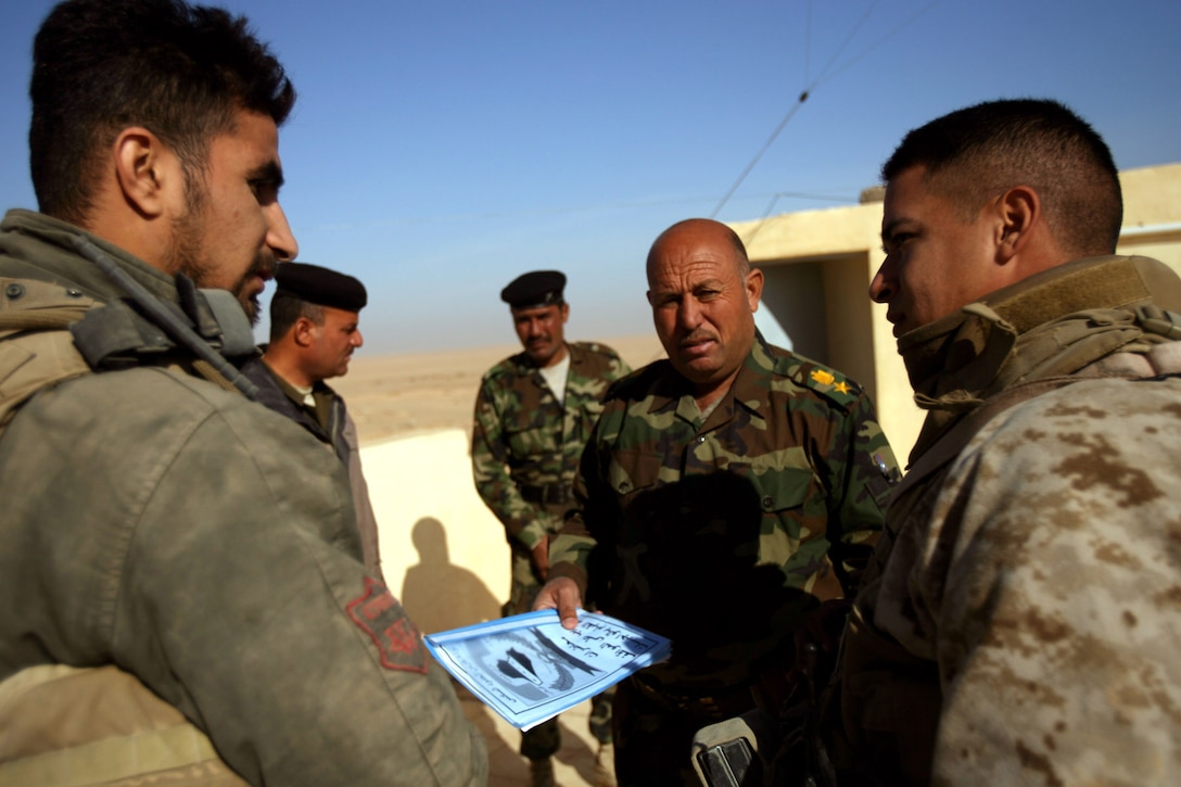 Sgt. Julian Bejarano, a 28-year-old section leader with Combined Anti-Armor Team Red, Weapons Company, Task Force 3rd Battalion, 7th Marine Regiment, Regimental Combat Team 5, talks to Lt. Col. Hamid Kniyaf, battalion executive officer for the Iraqi border guards, about future training operations between the two elements in western al-Anbar province, Iraq, Dec. 18.  The CAAT Marines plan to conduct training with the guards along the Iraqi and Syrian border to keep insurgents from crossing over the border.::r::::n::