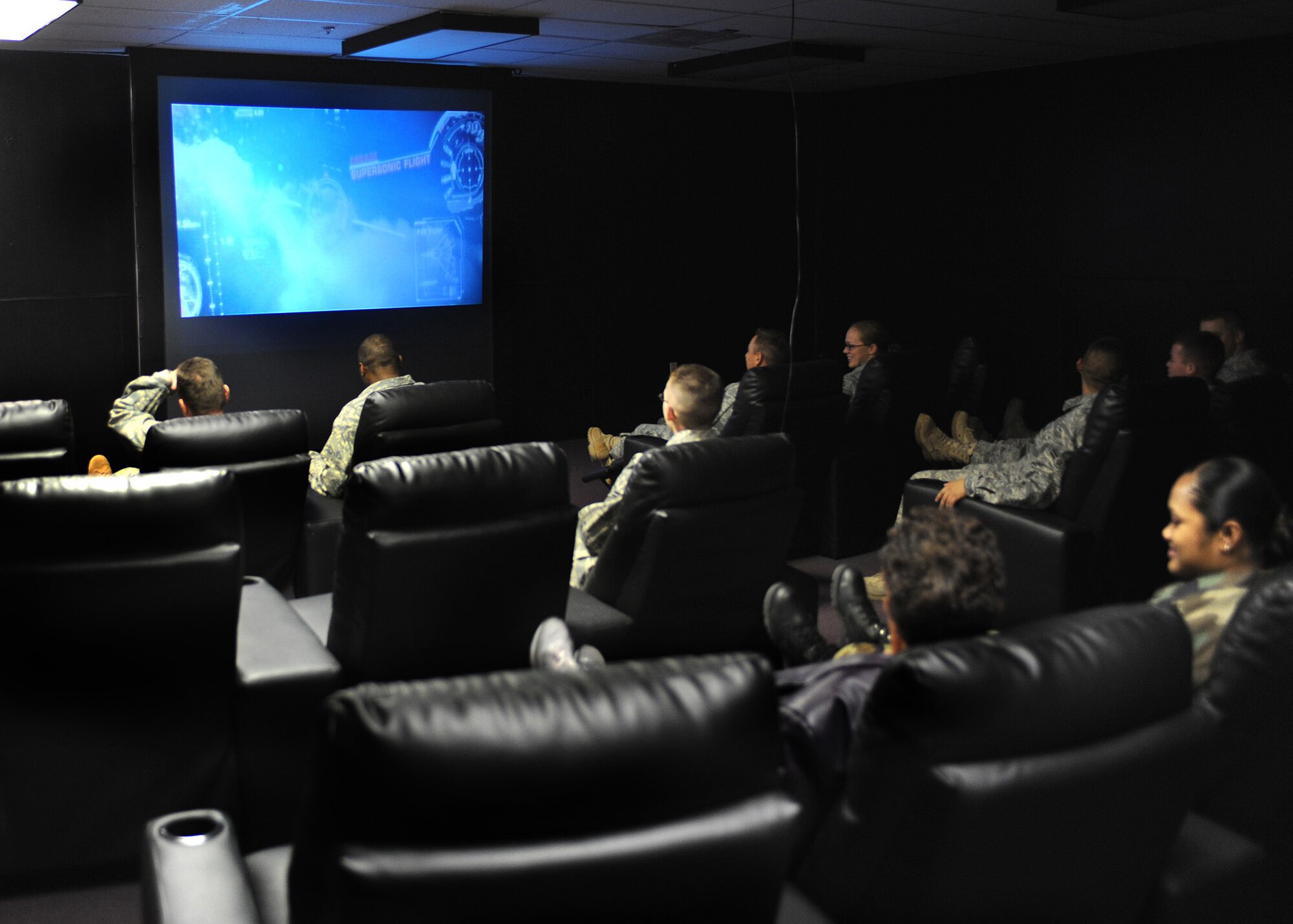 CANNON AIR FORCE BASE, N.M. -- Airmen enjoy the opening of the new Airmen's Center located above the End Zone Dec. 19. The new Airmen's Center consists of a movie room with reclining chairs, an overhead projector, surround sound, and a cyber cafe. There is also a second room devoted to gaming. (U.S. Air Force photo/Airman 1st Class Danielle Martin)