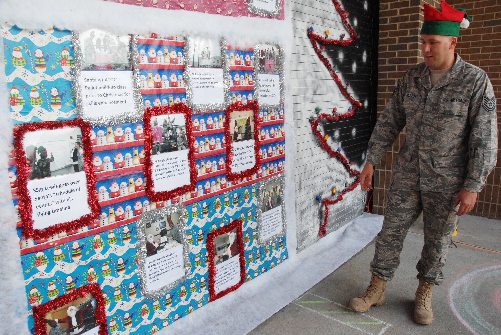 SHAW AIR FORCE BASE, S.C. -- Technical Sgt. Joseph Allen, 20th Logistics Readiness Squadron, explains how Santa Claus processed through the 20th LRS. The door decorations included a paper mache C-17 that dropped candy to children Thursday, Dec. 18 at the Deployment Processing Center. (U.S. Air Force photo/2nd Lt. Emily Chilson)