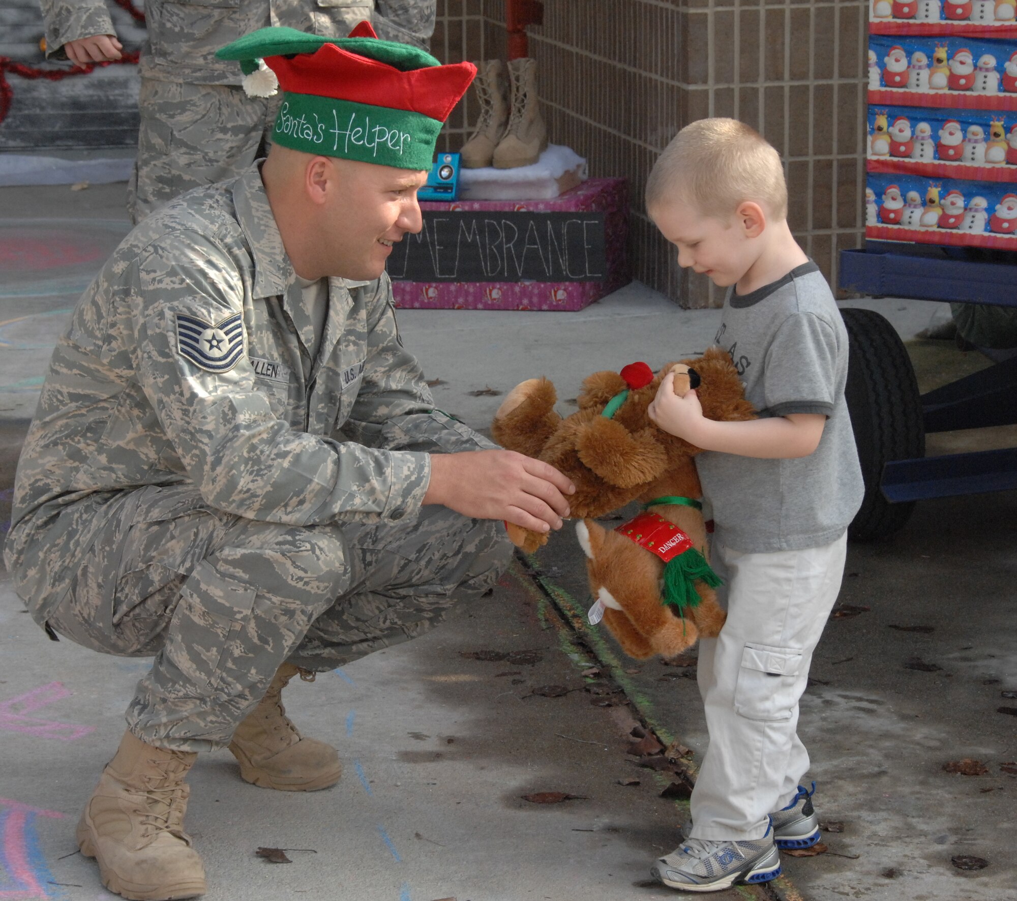 SHAW AIR FORCE BASE, S.C. -- A door decorating contest was taken to the next level outside the Deployment Processing Center when a paper mache C-17, incorporated into the decorated garage door, dropped candy to children. Technical Sgt. Joseph Allen, 20th Logistics Readiness Squadron, spreads holiday spirit to children at the DPC Thursday, Dec. 18. (U.S. Air Force photo/2nd Lt. Emily Chilson)