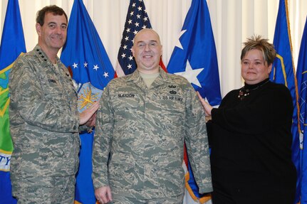 Gen. Stephen Lorenz (left), Air Education and Training Command commander, promotes Staff Sgt. Matt Slaydon to technical sergeant through the Stripes To Exceptional Performers, or STEP, program Dec. 19 at AETC Headquarters. Sergeant Slaydon's wife, Annette, helps the general tack on the stripe. General Lorenz conducted the on-the-spot promotion on behalf of Brig. Gen. Kurt Neubauer, 56th Fighter Wing commander, which is Sergeant Slaydon's home unit. He has been in San Antonio for more than a year receiving medical care for wounds he suffered Oct. 24, 2007, in Iraq when a bomb exploded next to him during his duty as an explosive ordnance disposal specialist.  Sergeant Slaydon received the promotion for the extensive Air Force ambassadorship and mentorship he has conducted during his year-long recovery. (Photo by Michelle Deleon)