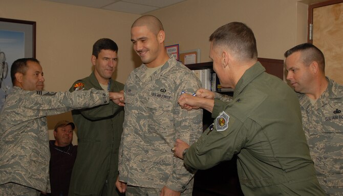 (from left) Chief Master Sgt. Anthony Martinez, 56th Operations Group Superintendent, Col. George Schaub, 56th Operations Group Commander, Chief Master Sgt. Randall Raper, 56th Fighter Wing Command Chief, and Brig. Gen. Kurt Neubauer, 56th Fighter Wing Commander tack on technical sergeant stripes onto the former Staff Sgt. Michael Cox, 56th Operations Support Squadron, during a sneak STEP promotion Dec. 18.  The Stripes for Exceptional Performers program allows base commanders a method to promote individuals who are outstanding performers, but may not have been promoted under the traditional Weighted Airmen Promotion System. (U.S. Air Force photo/Airman 1st Class Ronifel Yasay)