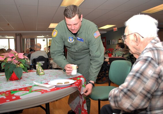 Tech. Sgt, Ken Steiner serves coffee to a veteran at the Soldiers' Home in Holyoke, Mass., Dec. 18. Sergeant Steiner and more than 30 other reservists from the 439th Airlift Wing at Westover paid a holiday visit to the veterans. (US Air Force photo/Tech. Sgt. Andrew Biscoe)