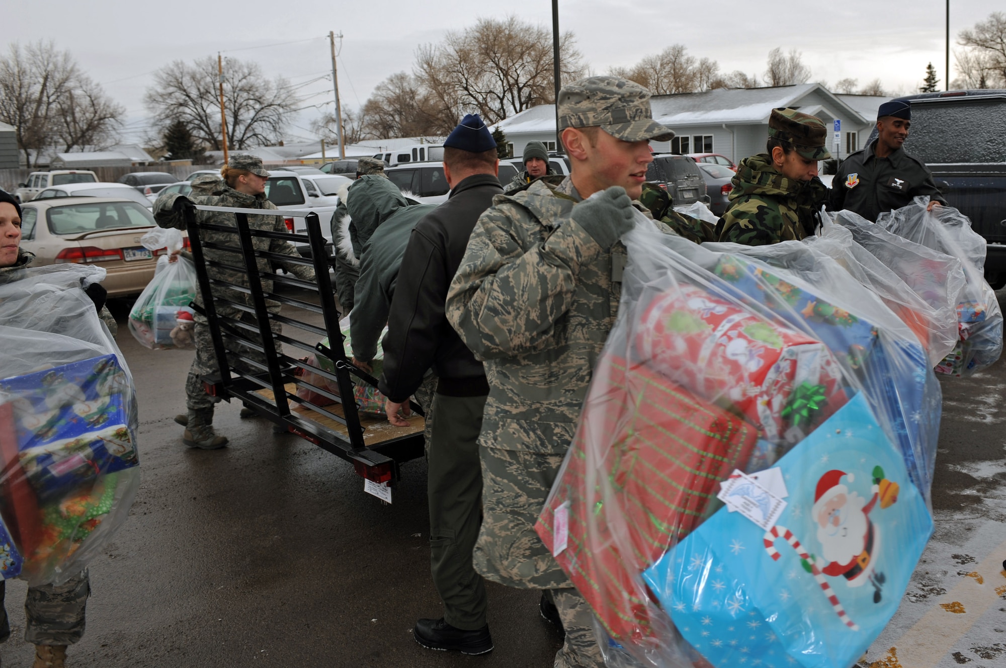Airman 1st Class Zachary Aichele, 28th Operational Support Squadron radio communications journeyman, carries a bag of presents into the Youth and Family Services Child Care Center in Rapid City, S.D., Dec. 18, 2008. 28th Operations Group personnel unloaded presents and helped Santa distribute presents to children at the center. (US Air Force photo/Airman 1st Class Corey Hook)