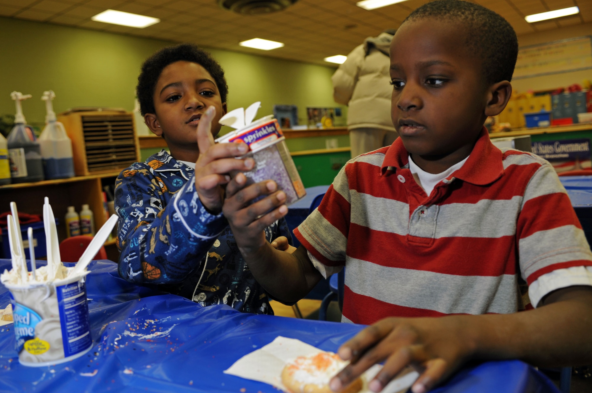(Right to Left) Jeremy Linville and Lloyd Shanklin make cookies for themselves and their parents during a Santa visit at the Youth Center here, Dec. 18. The children ate food brought from families of Youth Center children and shaped cookies and crafts during Santa’s Visit. (US Air Force photo/Airman 1st Class Corey Hook)