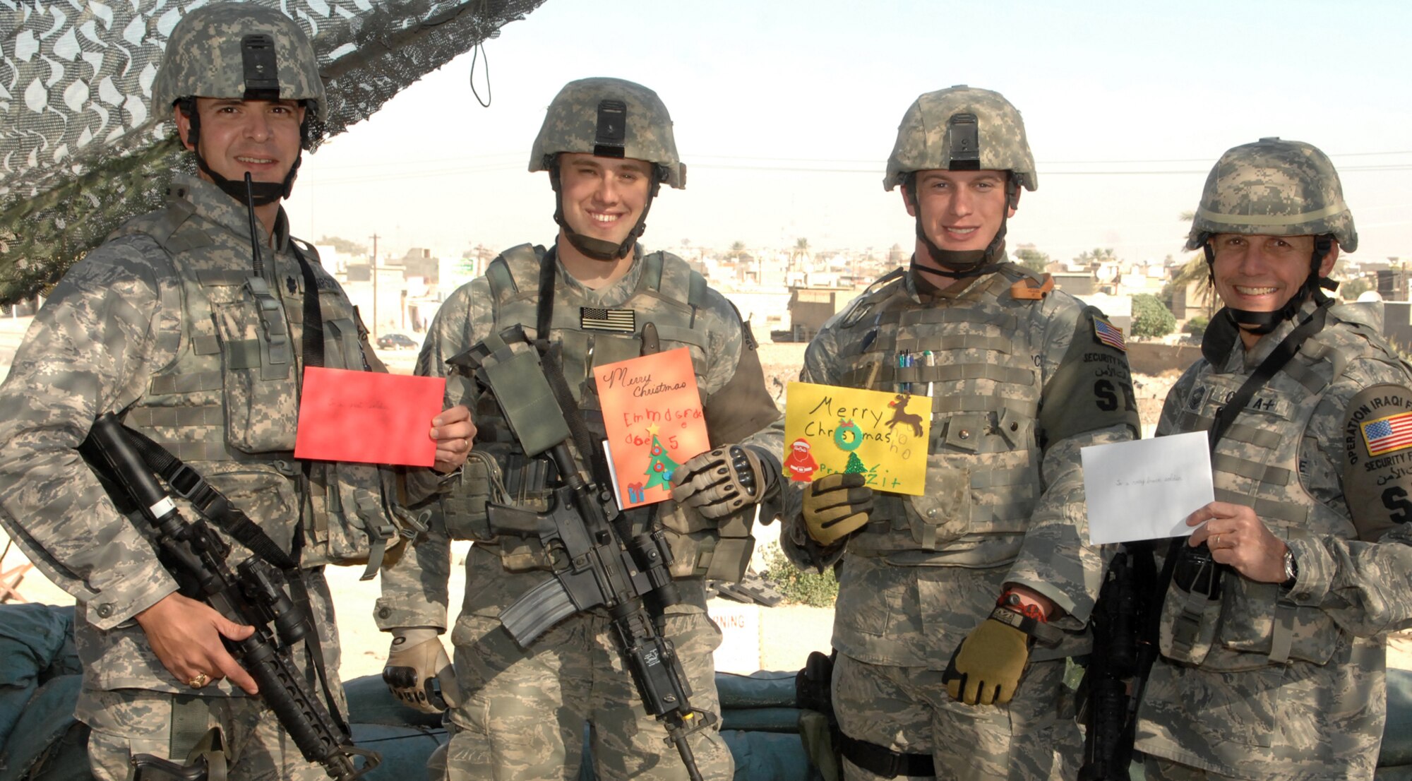 Lt. Col. Chris Simpson, 506th Expeditionary Security Forces Squadron commander, left, and Chief Master Sgt. Jeff Cain, 506th ESFS manager, right, distributed Christmas cards Dec. 15, 2008, to Staff Sgt. Casey Karins, second from left, and Senior Airman Joshua Moffie, both 506th ESFS fire team members.  Residents of Colonel Simpson's hometown of Gulf Breeze, Fla., sent more than 400 cards to the squadron, which will be distributed to the security forces Airmen during the holidays. (U.S. Air Force Photo/Senior Airman Randi Flaugh)


