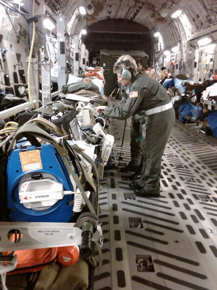 RAMSTEIN AIR BASE, Germany - Capt. Leesa Lowder, 445th Aeromedical Evacuation Squadron, assists a patient in flight from Ramstein Air Base, Germany to Andrews Air Force Base on a C-17.  The AES members are deployed to Ramstein Air Base to provide patient care on all flights from Southwest Asia back to the United States. (Air Force photo/Capt. Jonathan Kollmann)