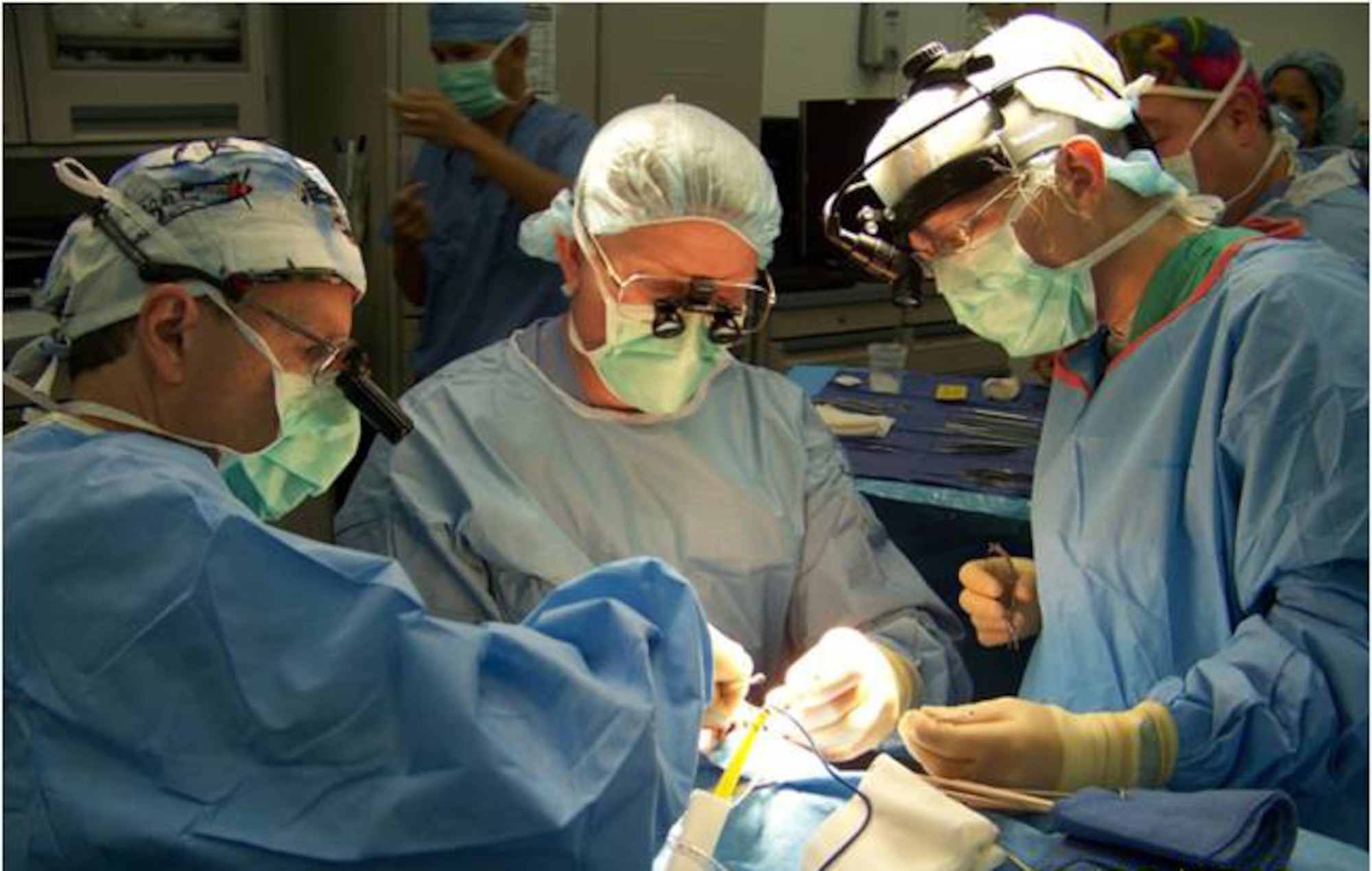 Ophthalmologists Col. (Dr.) Randy Beatty, Maj. (Dr.) Lisa Mihora, and Col. (Dr.) David Holck (left to right) repair an orbital fracture at the Air Force Theater Hospital, Joint Base Balad, Iraq, June 20, 2008.  Major Mihora, an oculoplastics fellow at Wilford Hall Medical Center, Lackland Air Force Base, Texas, spent six weeks in Iraq as part of her training. (U.S. Air Force photo)