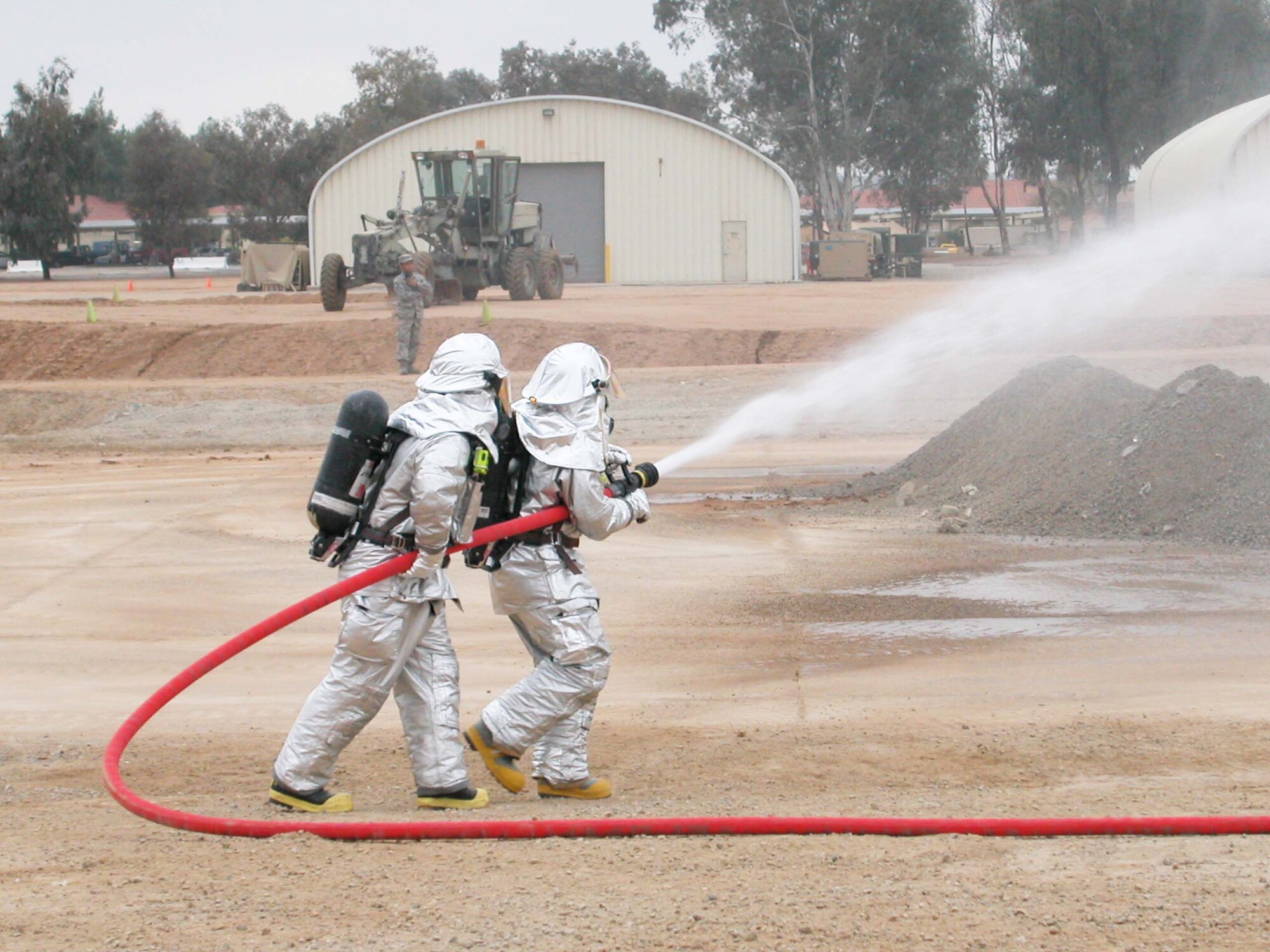 Members of the Fire Department put a stream on a mock fire during the Power Demonstration conducted Dec. 13 by the four flights of the 452nd Civil Engineer Squadron at March Air Reserve Base, Calif.  The purpose of the demonstration was to show family and base members the squadron's wartime capabilities. (U.S. Air Force photo by Senior Airman Kara McGrath)