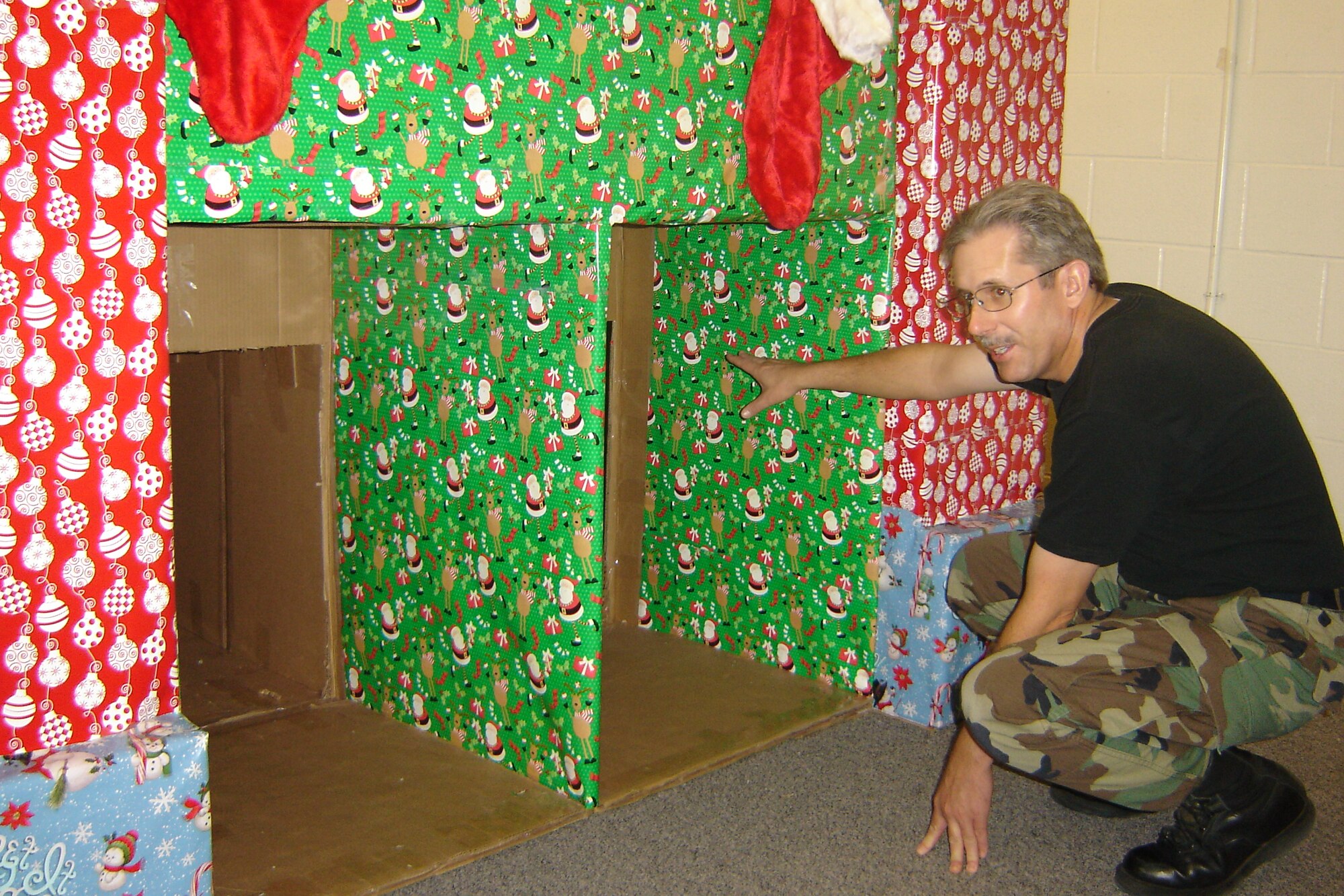 Senior Master Sgt.Mike Kastner, 452nd Civil Engineer Squadron, points inside the tunnels between the large towers of a section of Santa’s Village to show where kids can crawl through. Senior Master Sgt. Kastner has been building Santa's Village for the past four years for the children of personnel at March Air Reserve Base, Calif. (U.S. Air Force photos by Will Alexander)