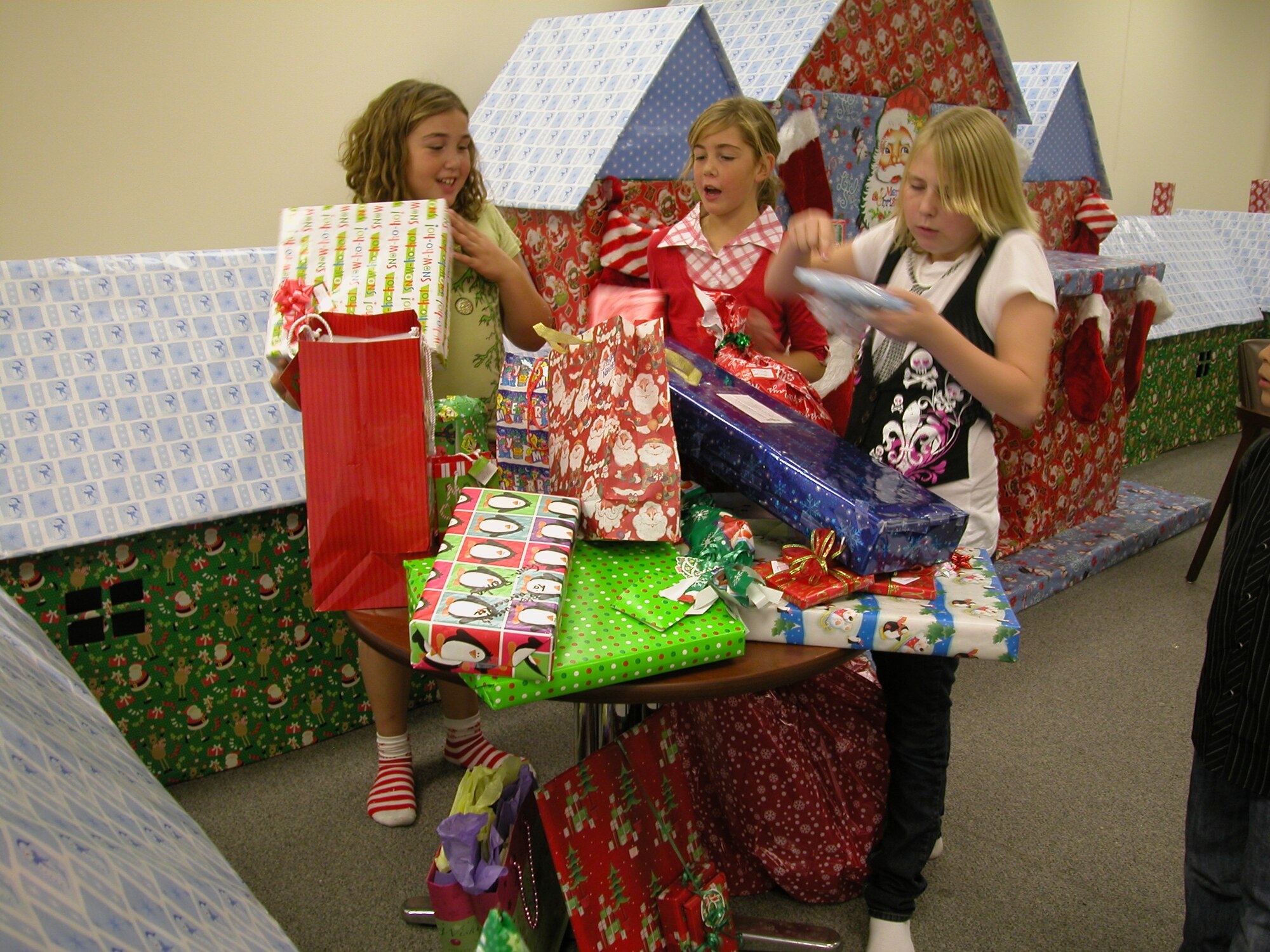 (Left to right) Desiree Elliott, Bee Elliott and Sydney Harnos shake gifts that their parents brought for Santa to distribute to children during the 452nd Civil Engineer Squadron Christmas Party, Dec. 13 inside Santa’s Village at March Air Reserve Base, Calif. Santa’s Village was built by Senior Master Sgt. Mike Kastner, senior Air Reserve Technician at 452 CES. (U.S. Air Force photo by Staff Sgt. Megan Crusher)