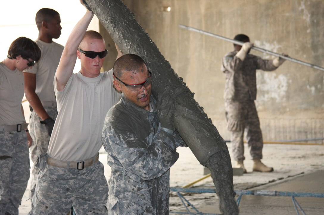 BALAD AIR BASE, Iraq -- Staff Sgt. Jarrett Pablo, a heavy equipment operator deployed from the 30th Civil Engineer Squadron,  pours concrete for a project in Iraq. Sergeant Pablo received on-the-spot recognition as the 54th Engineer Battalion Warrior of the Week by Army Command Sgt. Maj. Eric Omundson for his work on the project. (U.S. Army photo) 
