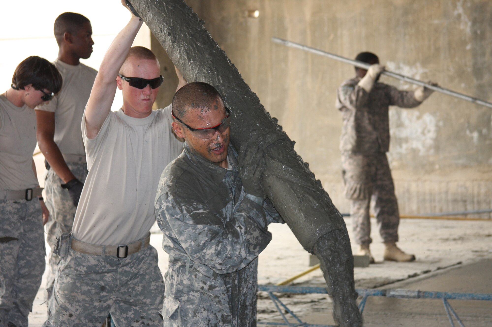 BALAD AIR BASE, Iraq -- Staff Sgt. Jarrett Pablo, a heavy equipment operator deployed from the 30th Civil Engineer Squadron,  pours concrete for a project in Iraq. Sergeant Pablo received on-the-spot recognition as the 54th Engineer Battalion Warrior of the Week by Army Command Sgt. Maj. Eric Omundson for his work on the project. (U.S. Army photo) 