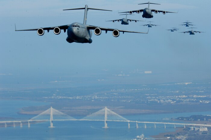 C-17s from Charleston AFB fly over the Arthur Ravenel Jr. Bridge Dec. 18. C-17s from the 437th and 315th Airlift Wings dropped cargo at a remote airfield during a strategic brigade airdrop exercise involving a 13-ship formation.  This multi-ship training demonstrates the teamwork of active-duty Airmen, Reservists and civilians to be mission-ready when the nation needs this critical capability. (U.S. Air Force photo/Staff Sgt. Richard Rose) 