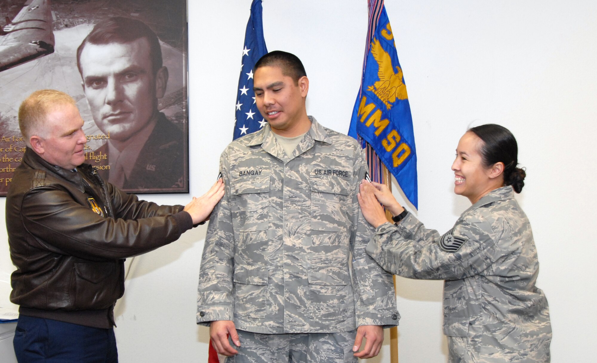 Col. Jerry Gandy (left), 95th Air Base Wing commander, and Tech. Sgt. Jenny Bangay, installation exercise program noncommissioned officer in charge, tack on a new stripe for Tech. Sgt. Kenneth Kapono Bangay, 95th Communications Group core services and network administrator, during a ceremony Dec. 19. Sergeant Bangay was promoted to the rank of technical sergeant through the Stripes to Exceptional Performers program, or STEP. (Air Force photo by Senior Airman Julius Delos Reyes)