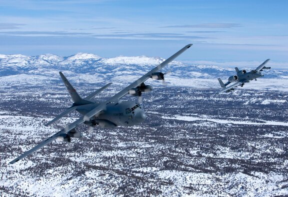An A-10A Thunderbolt II and a C-130E Hercules, both from the 124th Wing Idaho Air National Guard, fly in formation over Idaho's Sawtooth Mountain Range. (Photo by Mr James Haseltine)