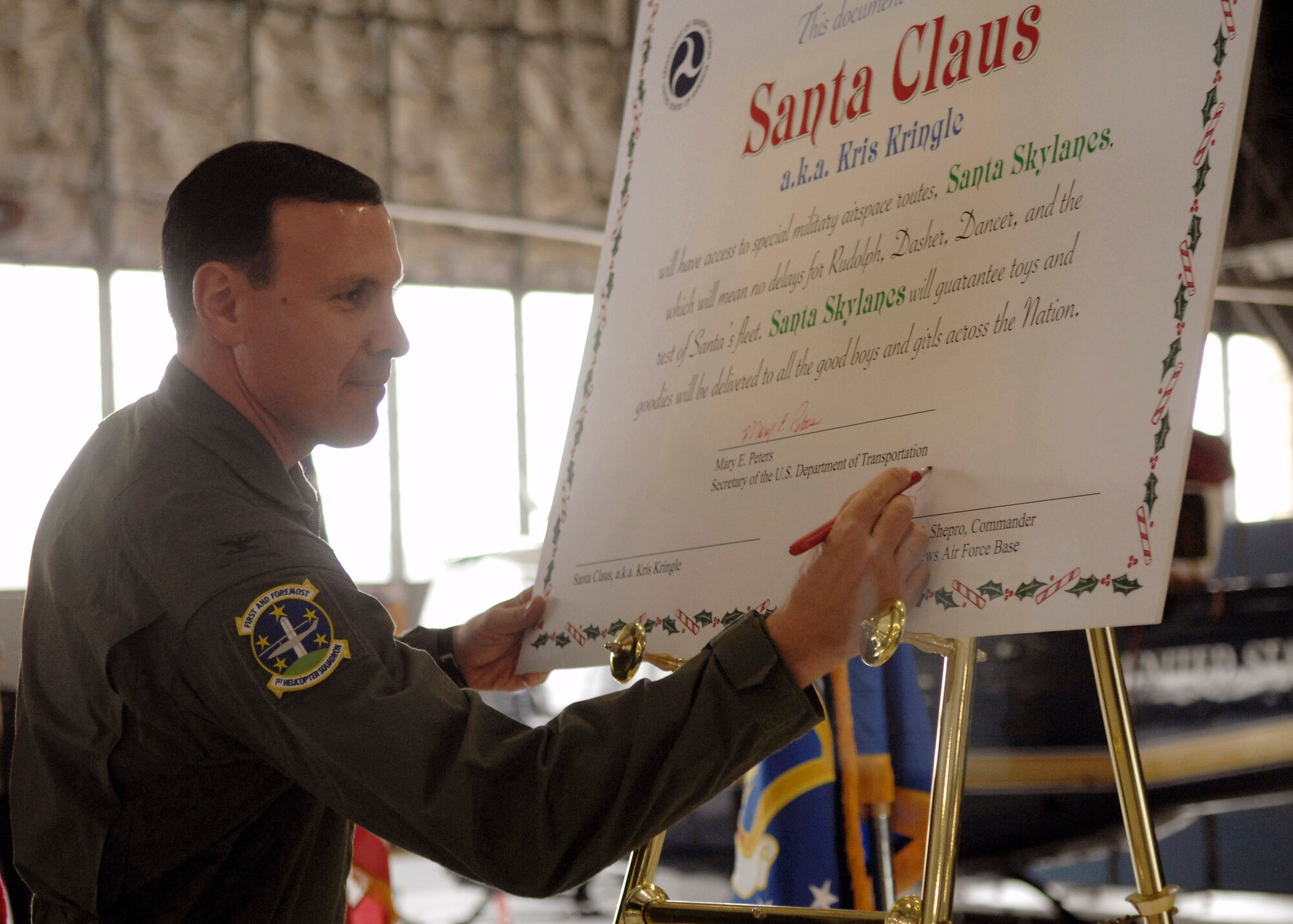 Colonel Steven Shepro signs a document permitting Santa Claus to use designated military airspace Christmas Eve night Dec. 18 at Andrews Air Force Base, Md. The document allows Santa to use "Santa Skylanes" without any delays in order to deliver toys to all the good boys and girls around the world. Colonel Shepro is the 316th Wing commander. (U.S. Air Force photo/Senior Airman Melissa Stonecipher) 
