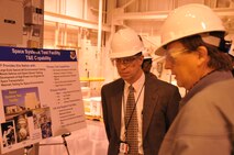 Right, Jim Burns, Field Test Flight director for the 718th Test Squadron briefs Britt Covington, center, AEDC’s new executive director, in the center’s Mark I Space Chamber during Covington’s tour Wednesday. (Photo by David Housch)