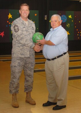 ALTUS AIR FORCE BASE, Okla. -- Chief Master Sgt. Chuck Adams, 97th Operational Support Squadron, and Mr. Terry Kratz, 97th Logistics Readiness Squadron, display the bowling ball presented to Mr. Kratz for raising the most pledge money during the annual Chiefs’ Group bowl-a-thon. (U.S. Air Force photo/Airman 1st Class Tiffany M. Deuel)