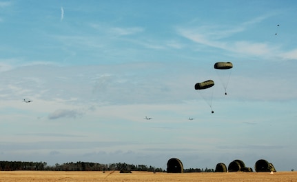 Globemaster IIIs from the 437th and 315th airlift wings drop cargo at a remote airfield during a strategic brigade airdrop exercise involving a 13-ship formation Dec. 18 from Charleston Air Force Base, S.C. C-17s must be able to meet the Army's goal of airdropping a brigade's worth of troops and equipment (about 3,250 Soldiers and 3,450 tons of equipment). Charleston AFB aircraft currently account for half of the Air Force strategic brigade airdrop requirement. (U.S. Air Force photo/Tech. Sgt. William Greer) 