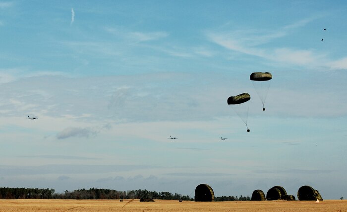 Globemaster IIIs from the 437th and 315th airlift wings drop cargo at a remote airfield during a strategic brigade airdrop exercise involving a 13-ship formation Dec. 18 from Charleston Air Force Base, S.C. C-17s must be able to meet the Army's goal of airdropping a brigade's worth of troops and equipment (about 3,250 Soldiers and 3,450 tons of equipment). Charleston AFB aircraft currently account for half of the Air Force strategic brigade airdrop requirement. (U.S. Air Force photo/Tech. Sgt. William Greer) 