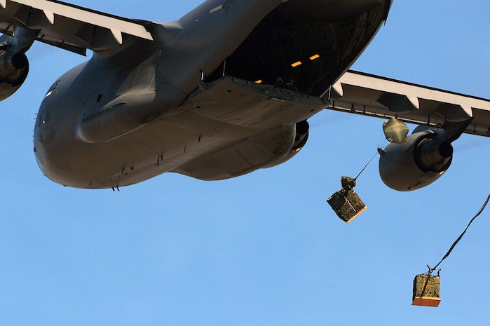 C-17 Globemaster IIIs from the 437th and 315th airlift wings drop cargo at a remote airfield during a strategic brigade airdrop exercise involving a 13-ship formation Dec. 18 from Charleston Air Force Base, S.C. C-17s must be able to meet the Army's goal of airdropping a brigade's worth of troops and equipment (about 3,250 Soldiers and 3,450 tons of equipment). Charleston AFB aircraft currently account for half of the Air Force strategic brigade airdrop requirement. (U.S. Air Force photo/Tech. Sgt. William Greer) 