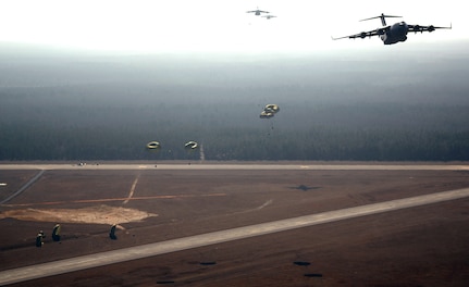 C-17 Globemaster IIIs from the 437th and 315th airlift wings drop cargo at a remote airfield during a strategic brigade airdrop exercise involving a 13-ship formation Dec. 18 from Charleston Air Force Base, S.C. C-17s must be able to meet the Army's goal of airdropping a brigade's worth of troops and equipment (about 3,250 Soldiers and 3,450 tons of equipment). Charleston AFB aircraft currently account for half of the Air Force strategic brigade airdrop requirement. (U.S. Air Force photo/Tech. Sgt. Jeremy Lock)