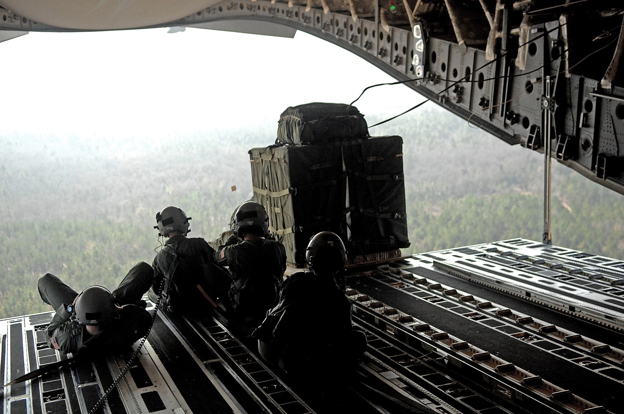 C-17 Globemaster IIIs from the 437th and 315th airlift wings drop cargo at a remote airfield during a strategic brigade airdrop exercise involving a 13-ship formation Dec. 18 from Charleston Air Force Base, S.C. C-17s must be able to meet the Army's goal of airdropping a brigade's worth of troops and equipment (about 3,250 Soldiers and 3,450 tons of equipment). Charleston AFB aircraft currently account for half of the Air Force strategic brigade airdrop requirement. (U.S. Air Force photo/Tech. Sgt. Jeremy Lock) 