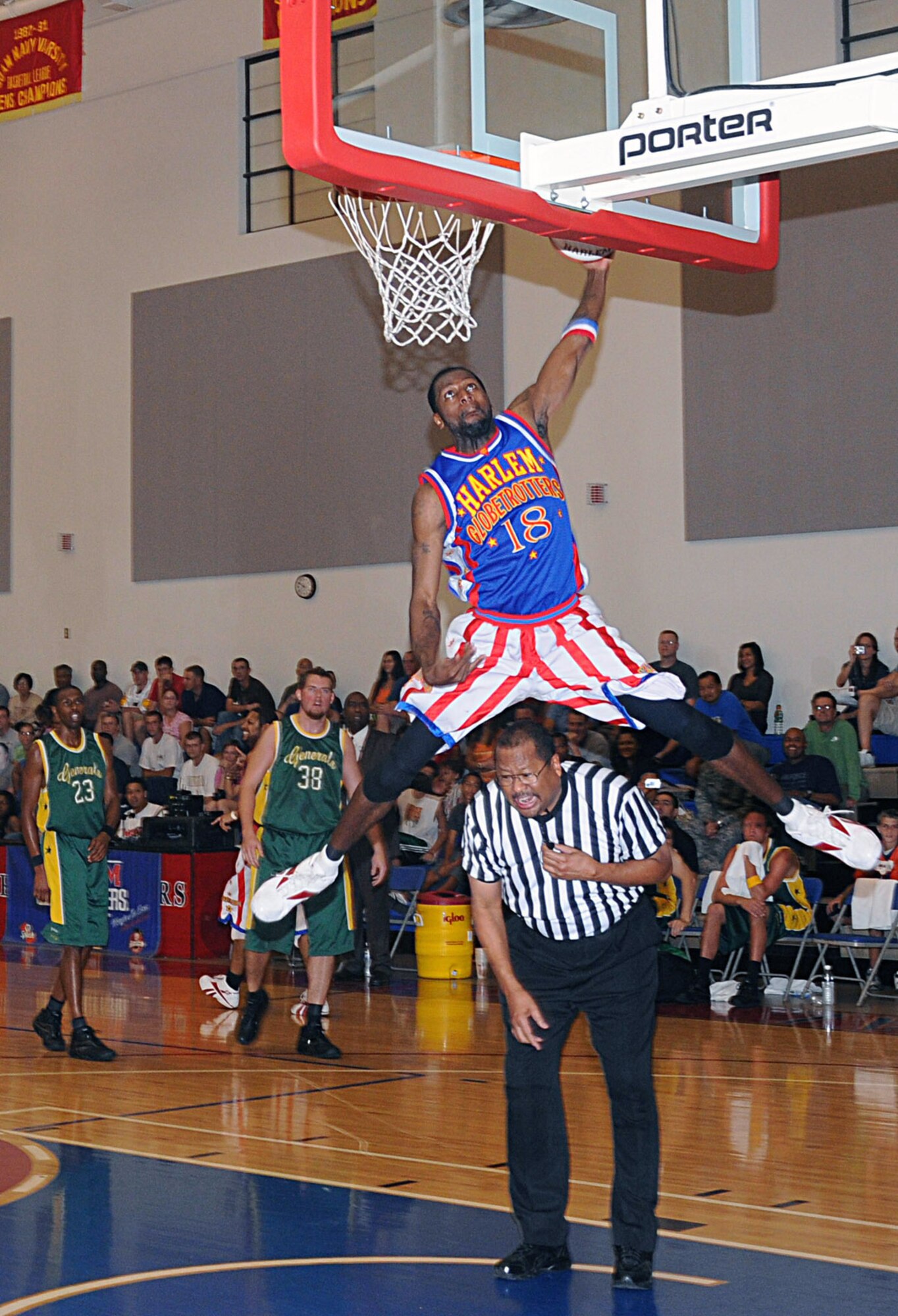 Jermaine "Hi Rise" Brown leapfrogs over the referee to slam dunk the ball Dec. 15 at Andersen Air Force Base, Guam. The Harlem Globetrotters entertained base Airmen and their families during a game against the Washington Generals. (U.S. Air Force photo/Staff Sgt. Jamie Lessard) 
