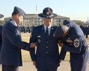 Brig. Gen. Len Patrick (left), 37th Training Wing commander, and Chief Master Sgt. Juan Lewis, 37th TRW command chief, give Tech. Sgt. Justin Apticar master sergeant stripes Dec. 12. Sergeant Apticar, 737th Training Group, received an immediate promotion as part of the Stripes for Exceptional Performers Program. (USAF photo by Alan Boedeker)