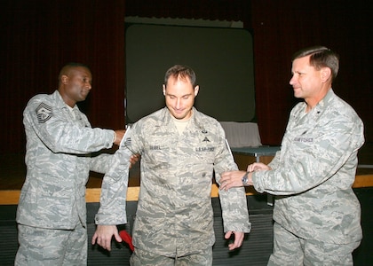 Chief Master Sgt. Juan Lewis (left), 37th Training Wing command chief, and Brig. Gen. Len Patrick, 37th TRW commander, give Staff Sgt. Nicholas Seibel technical sergeant stripes Dec. 16. Sergeant Seibel, 342nd Training Squadron, received an immediate promotion as part of the Stripes for Exceptional Performers Program. (USAF photo by Robbin Cresswell)