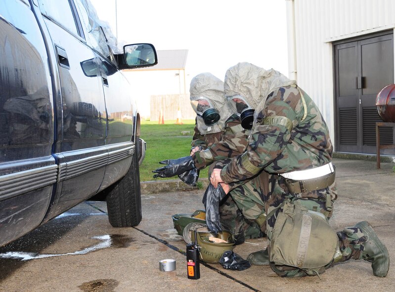 Senior Airman Jonathon Spell, front, and Airman 1st Class Brent Reich, both 100th Logistics Readiness Squadron, quickly put on more MOPP gear after an "Alarm Red, MOPP 4" announcement during the exercise Dec. 11. The exercise was held to help RAF Mildenhall prepare for the Operational Readiness Inspection in 2009. (U.S. Air Force photo by Karen Abeyasekere)