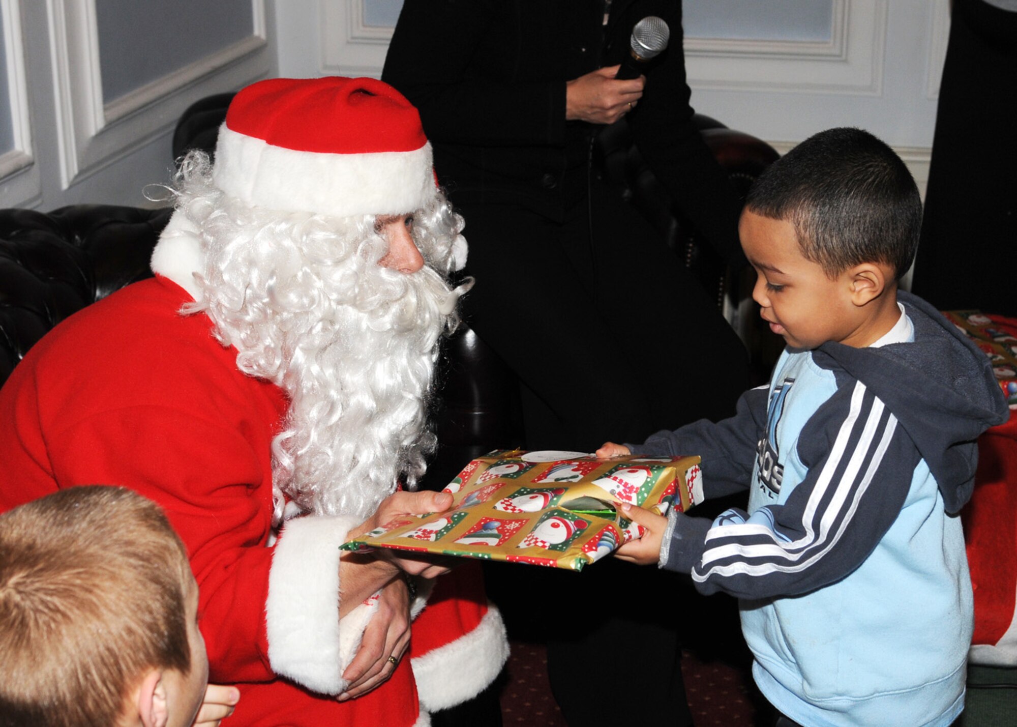 Kaidan Fleshman 3, son of Staff Sgt. Jerry Fleshman from the 100th Public Affairs, accepts a gift from Santa Claus during the deployed spouse’s luncheon Dec. 7, 2008, in RAF Marham, England. Santa made a special appearance and handed out gifts to all children in attendance. (U.S. Air Force photo by Staff Sgt. Jerry Fleshman)