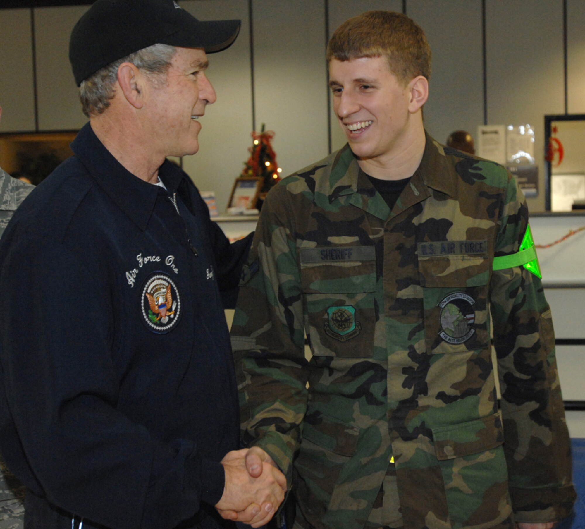 President George W. Bush shakes hands and exchanges laughs with Airman First Class Nathan Sheriff, 727th Air Mobility Squadron during a brief visit here Dec 15, 2008. (U.S. Air Force photo by Senior Airman Teresa Hawkins)