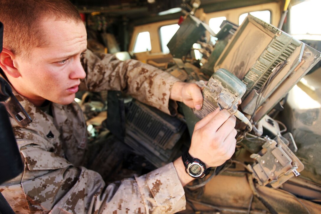 Cpl. Jeremy C. Olson, 22, tech shop supervisor for Headquarters and Service Company, Task Force 3rd Battalion, 7th Marine Regiment, Regimental Combat Team 5, installs communication gear into a vehicle at Combat Outpost Ubaydi, Iraq, Dec. 18.  From running wires and maintaining internet connectivity to fixing radios, the communications Marines work around the clock.::r::::n::