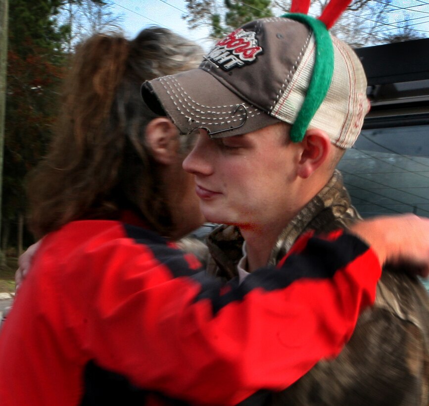 Cpl. Jarod Fox, mechanic, General Support Maintenance Company, 2nd Maintenance Battalion, 2nd Marine Logistics Group, is hugged by an Angel Food recipient as an expression of gratitude to the young Marine, Dec. 20.  The Marines helped unload a tractor-trailer full of food and distribute it to families in need at the Trinity United Methodist Church in Jacksonville, N.C.
