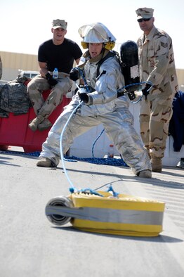 SOUTHWEST ASIA -- Staff Sgt. Justin VanDusen from the 380th Expeditionary Security Forces Squadron drags a 5-inch diameter, 50-foot hose over 100 feet during the 380th Firefighter Challenge held Dec. 20 here. The Firefighter Challenge gave Airmen the opportunity to don firefighter gear and be timed while performing various physical tasks. Sergeant VanDusen is deployed from the 355th SFS, Davis-Monthan Air Force Base, Ariz., his hometown is Coldwater, Mich. (U.S. Air Force photo/Tech. Sgt. Christopher A. Campbell)(released)