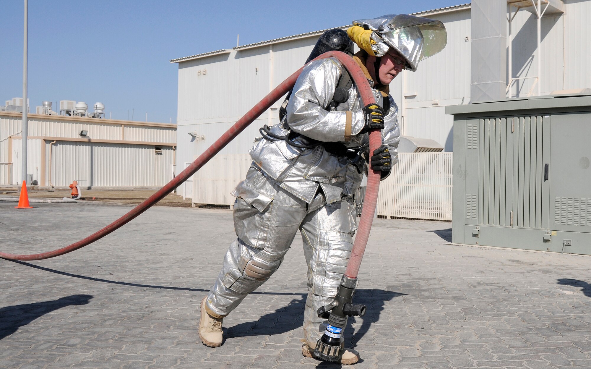 SOUTHWEST ASIA -- Second Lieutenant Sarah Rothlisberg from the 380th Expeditionary Security Forces Squadron drags a water-pressurized hose over 100 feet during the 380th Firefighter Challenge held Dec. 20 here. The Firefighter Challenge gave Airmen the opportunity to don firefighter gear and be timed while performing various physical tasks. (U.S. Air Force photo/Tech. Sgt. Christopher A. Campbell)(released).