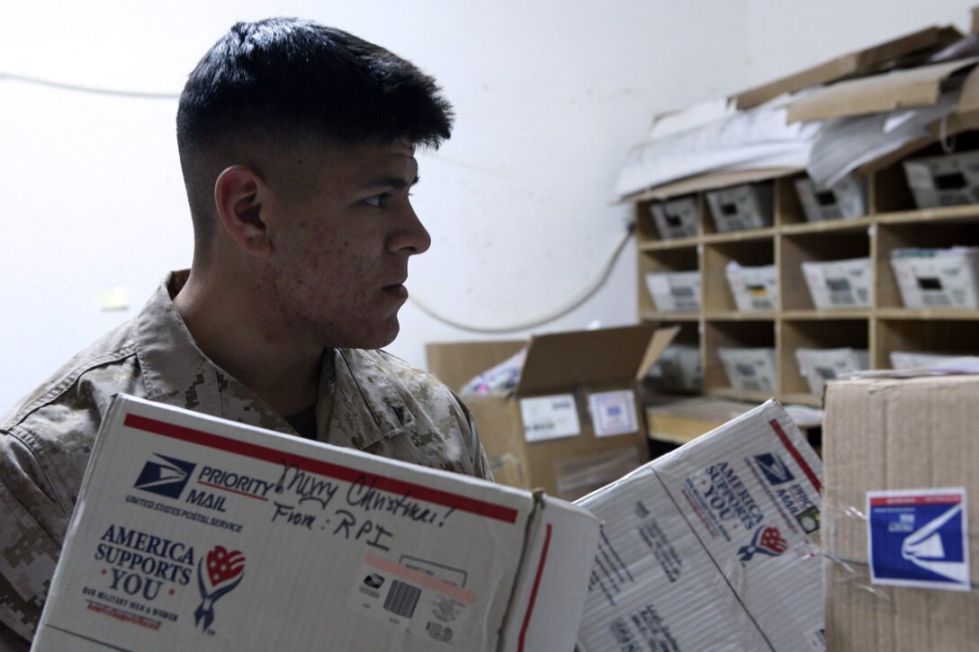 Lance Cpl. Michael Dunn, mail clerk with Regimental Combat Team 5, sorts packages in the mail room on Camp Ripper, Iraq, Dec. 20. Dunn is responsible for distributing the care packages and holiday gifts from the caring groups and individuals whose gestures of appreciation to service members deployed during the holidays are well-received and appreciated in return.::r::::n::