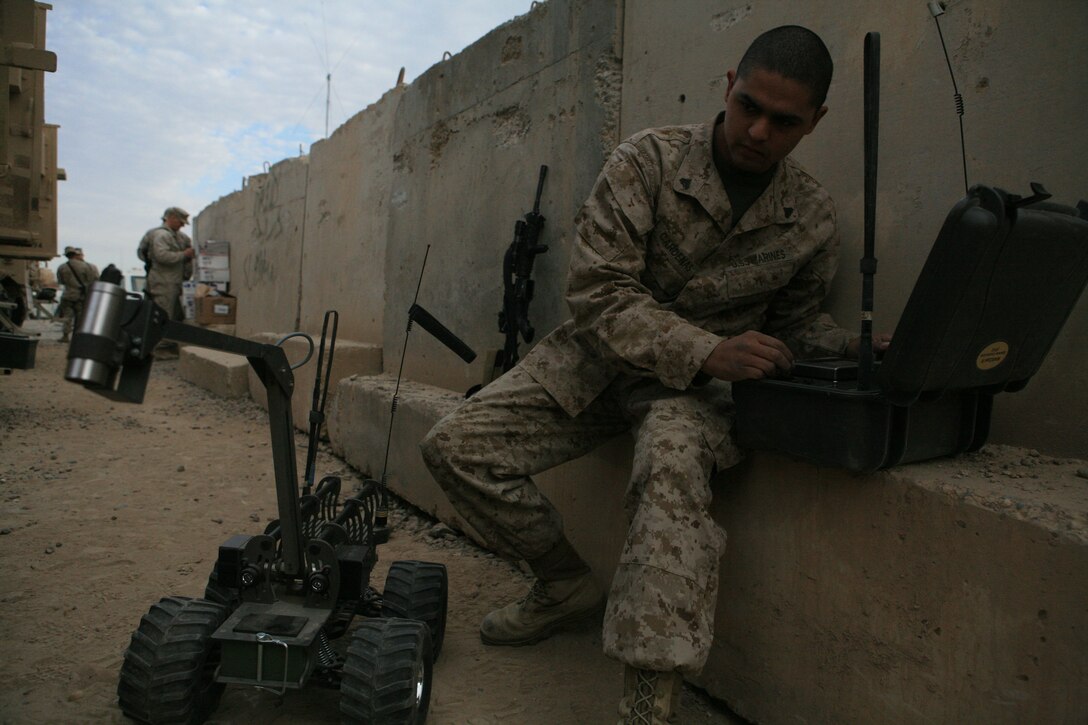 Cpl. Raul Cardenas, 24, from Santa Ana, Calif., vehicle commander for 2nd Squad, Security Company, Combat Logistics Battalion 5, 1st Marine Logistics Group, prepares a Multi-function Agile Remote Control Robot prior to a mission Dec. 20. Security Co. uses the MARCbot to safely investigate possible Improvised Explosive Devices. Security Co. ensures that convoys reach their destination safely by providing security throughout the trip.