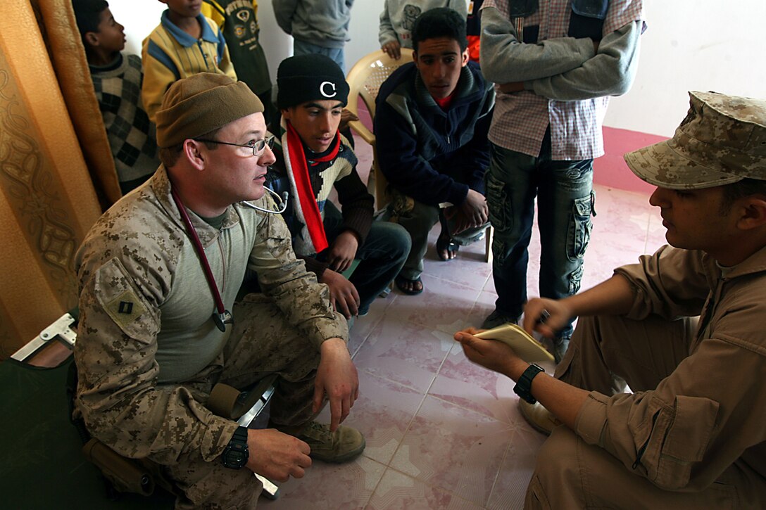 Navy Lt. Scott N. Margraf, medical officer, Security Force, Marine Wing Support Squadron 373, 1st Marine Logistics Group, sees to the ailments of Iraqi children at the new Kabani medical clinic here Dec. 20. Margraf, 42, Sasebo, Japan, was one of a few doctors present for the clinic?s ribbon cutting ceremony and subsequent medical engagement. The new Kabani Medical Clinic provides a venue for future medical engagements and Iraqi doctors to use to treat Kabani?s population. Engaging with the populace is critically important to mission accomplishment in Iraq, said Margraf. Kabani, a small village just east of Camp Taqaddum, used to host civil affairs engagements and visits from their own Iraqi medical practitioners in whatever structures they had available. Through a combination of diplomatic action from Iraqi and Coalition Forces, the village now has a necessary venue for health care. The combined medical engagement was one of many 1st MLG has performed since taking over for 2nd MLG in February of this year. The new clinic in Kabani marks the first of many recent steps toward improvements of Iraqi infrastructure.