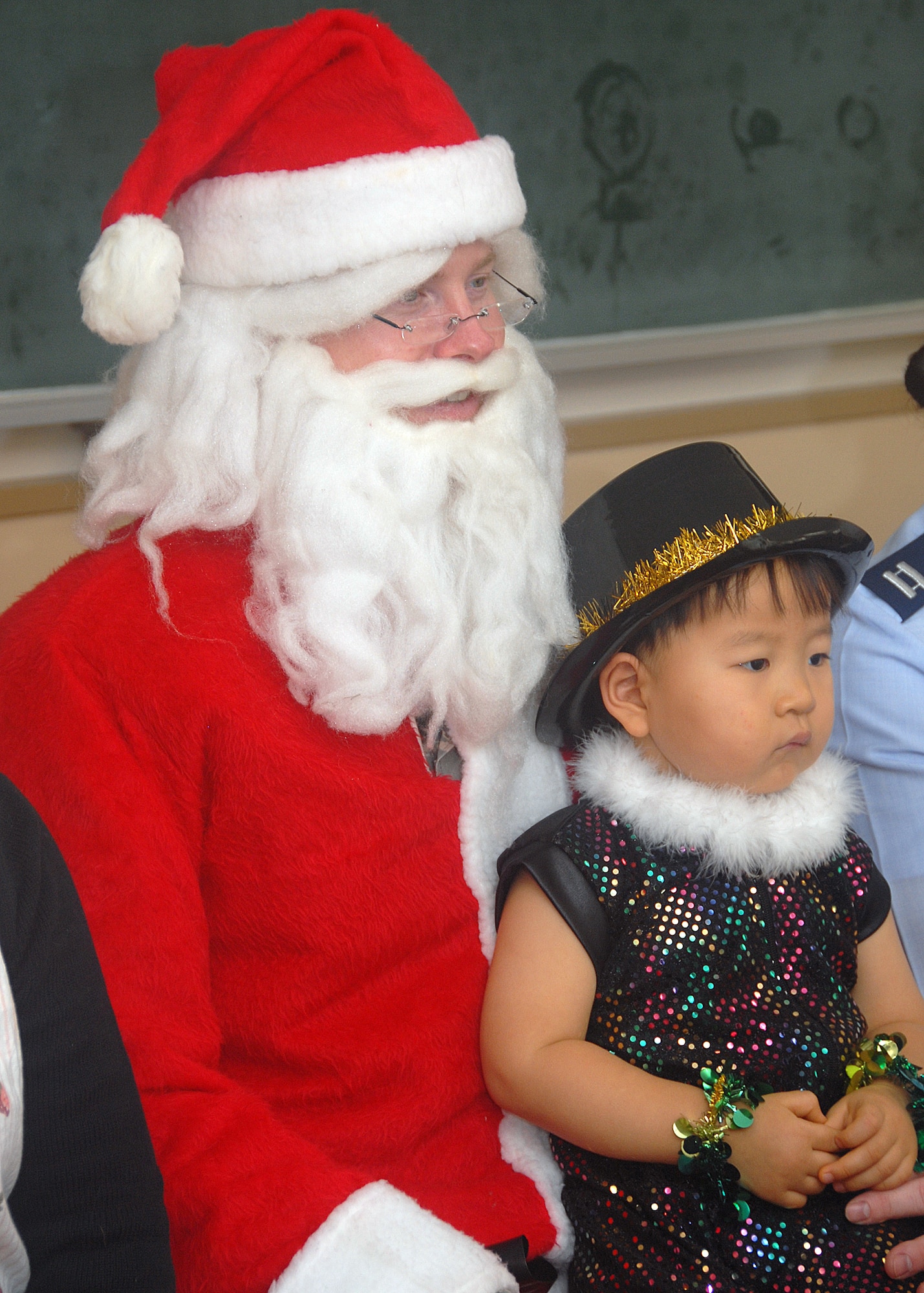 MISAWA AIR BASE, Japan -- As Santa Claus, volunteer Staff Sgt. Jonathan Moeller, vehicle operations dispatcher, 35th Logistics Readiness Squadron, holds a local Misawa child on his lap for a picture Dec. 18, 2008. Sergeant Moeller along with members of the Misawa Company Grade Officers Council visited Misawa Municipal Chuo Child Care Center to hand out candycanes and share the Christmas spirit with more than 150 local children, ages one to five. (U.S. Air Force photo by 2nd Lt. Jeff M. Nagan)