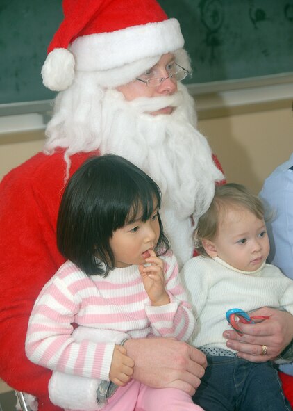 MISAWA AIR BASE, Japan -- As Santa Claus, volunteer Staff Sgt. Jonathan Moeller, vehicle operations dispatcher, 35th Logistics Readiness Squadron, holds two children on his lap for a picture Dec. 18, 2008. Sergeant Moeller along with members of the Misawa Company Grade Officers Council visited Misawa Municipal Chuo Child Care Center to hand out candycanes and share the Christmas spirit with more than 150 local children, ages one to five. (U.S. Air Force photo by 2nd Lt. Jeff M. Nagan)