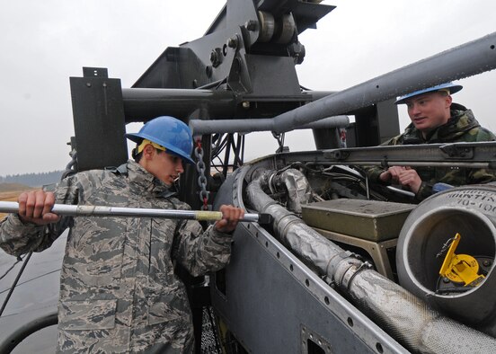 YOKOTA AIR BASE, Japan -- Senior Airman Mathew Vineyard, right, watches Airman 1st Class Jorge Espinosa-Velez torque an upper mount bolt on a T56 engine Dec. 17. The Airmen work for the 374th Maintenance Squadron engine test cell. (U.S. Air Force photo by Senior Airman Veronica Pierce)
